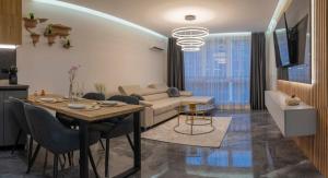 ein Wohnzimmer mit Tisch und Couch in der Unterkunft Luxury & Modern Apartment - Rowing Canal Plovdiv in Plowdiw