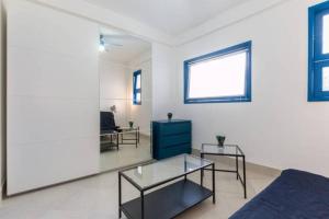 een woonkamer met een bank en 2 tafels bij Bilocale Scoglitti nei luoghi di Montalbano in Scoglitti