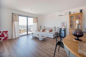 a living room with a couch and a table at 2 bedroom Sun & Terrace with sea view in San-Nicolao