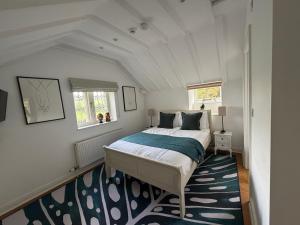 a bedroom with a bed and a blue rug at The Gatehouse at Pudleston Court in Hatfield