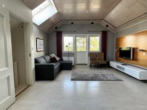 ein Wohnzimmer mit Sofa und Fernseher in der Unterkunft Villa Ateljeerinne in Jyväskylä