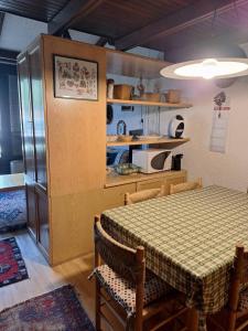 a dining room with a table and a kitchen at Casa Lolli in Madonna di Campiglio