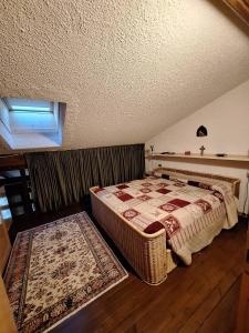 a bedroom with a bed and a window and a rug at Casa Lolli in Madonna di Campiglio +3 photos