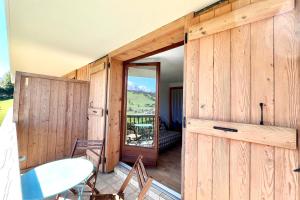 een houten kamer met een deur en een tafel op een dek bij Bright apartment with Mont Blanc view in Combloux