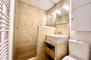 een badkamer met een wastafel, een toilet en een douche bij Bright apartment with Mont Blanc view in Combloux