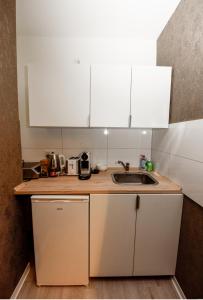 eine Küche mit weißen Schränken und einer Spüle in der Unterkunft Haus Thomas Deluxe 1 in Dortmund