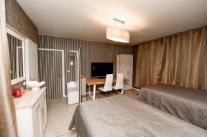 ein Schlafzimmer mit einem Bett und einem Schreibtisch mit einem Fernseher in der Unterkunft Haus Thomas Deluxe 1 in Dortmund