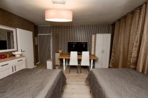 1 Schlafzimmer mit 2 Betten, einem Tisch und einem TV in der Unterkunft Haus Thomas Deluxe 1 in Dortmund