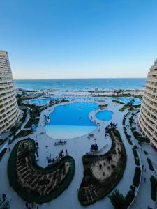 アインソフナにあるApartments porto Sokhna pyramids family onlyのリゾートの景色を望む2つのプールと海を望めます。