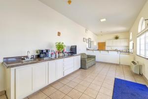 een grote keuken met witte kasten en een blauw tapijt bij Heights Inn by Townhouse Harker Heights, TX in Harker Heights