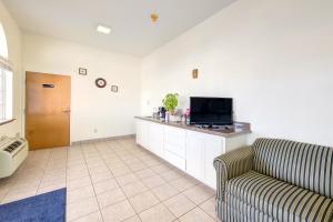 een woonkamer met een bank en een flatscreen-tv bij Heights Inn by Townhouse Harker Heights, TX in Harker Heights