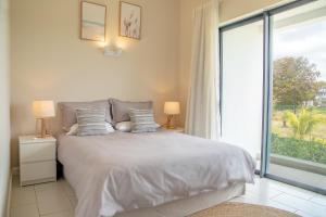 a bedroom with a bed and a large window at Serenity Pool Villa at Azuri in Roches Noires
