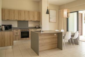 a kitchen with wooden cabinets and a table and chairs at Serenity Pool Villa at Azuri in Roches Noires