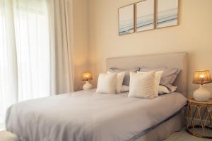 a bedroom with a white bed with white pillows at Serenity Pool Villa at Azuri in Roches Noires +53 photos