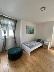 ein Schlafzimmer mit einem Bett und einer Ottomane in einem Zimmer in der Unterkunft Altbauvilla im Herzen von Lorsch in Lorsch