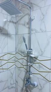 a shower in a bathroom with a marble wall at Wadi Rum Abu Khaled in Wadi Rum