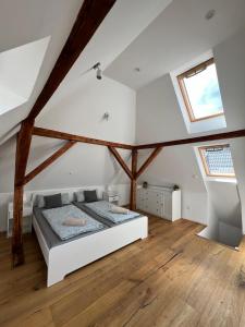 ein Schlafzimmer mit einem weißen Bett auf einem Dachboden in der Unterkunft Altbauvilla im Herzen von Lorsch in Lorsch
