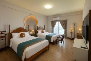 una habitación de hotel con dos camas y un televisor de pantalla plana en 澎湖藍海會館Blue Ocean Inn Penghu, en Magong 48 fotos más