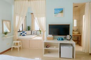 Una sala de estar con un sofá y un televisor. en 澎湖藍海會館Blue Ocean Inn Penghu, en Magong