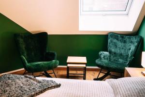 1 Schlafzimmer mit 2 grünen Stühlen und einem Bett in der Unterkunft Evergreen Cozy Apartment im Herzen von Durlach in Aue