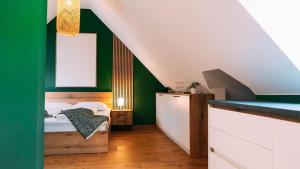 ein Schlafzimmer mit grünen und weißen Wänden und einem Bett in der Unterkunft Evergreen Cozy Apartment im Herzen von Durlach in Aue
