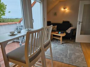 a living room with a table and chairs and a couch at Meeresfeeling in Horumersiel in Horumersiel +42 photos