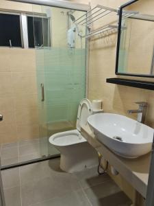 a bathroom with a sink and a toilet and a shower at Lucky 7 Homestay - Utama Court in Sandakan