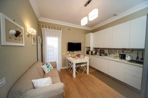 a living room with a couch and a small kitchen at Charming and Cozy House in Nettuno