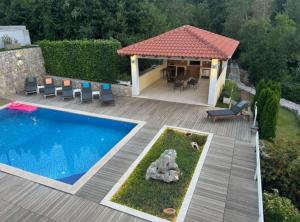 a backyard with a swimming pool and a house at Villa Oasis Cypress in Čilipi