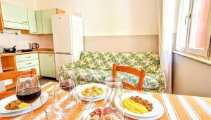 a table with plates of food and wine glasses at Strategico tra i MERCATiNi di Natale! zona centro storico - stazione in Trento