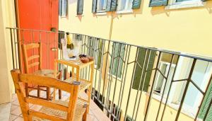 a balcony with a wooden chair and a table at Strategico tra i MERCATiNi di Natale! zona centro storico - stazione in Trento
