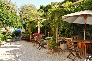 a patio with a table and chairs and an umbrella at Nice Garden Hotel in Nice