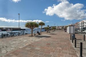 una persona sentada en un banco junto al agua en Apartamento Estrella, en Candelaria