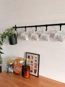 a shelf with coffee cups and a plant on it at Le Domaine Riverin in Pohénégamook