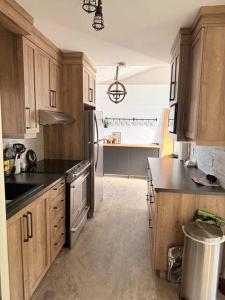 a kitchen with wooden cabinets and black counter tops at Le Domaine Riverin in Pohénégamook