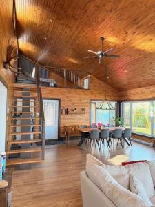 a living room with a couch and a dining room at Le Domaine Riverin in Pohénégamook