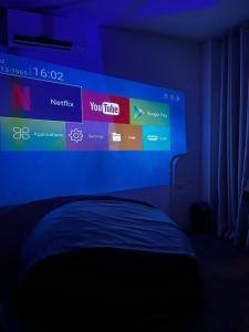 a bedroom with a large screen above a bed at Boxify Cabins in Alingaro