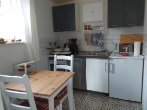 a kitchen with white cabinets and a wooden table at Alt Dwinge in Zwinge