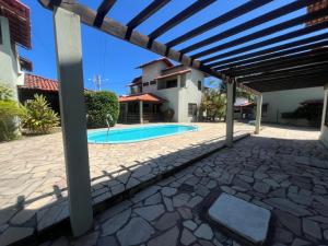 Casasveraneio casa top com 3 suítes com ar condicionado a 100 m da Praia - Barra de São Miguel, 7 minutos do gunga e 3 da praia bonita e conchas ! Área gourmet com piscina privativa e churrasqueira! condomínio com muito verde e piscina de 10m! في بارا دي ساو ميجيل: فناء امام منزل به مسبح