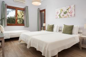 Dos camas en una habitación blanca con ventana. en The Sea House Skiathos, en Skiathos