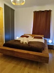 - une chambre avec un grand lit et un cadre en bois dans l'établissement Le Balcon du Snow Roc - Au pied des pistes, magnifique vue sur la vallée - Sauna, à Saint-Jean-dʼAulps