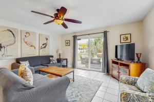 a living room with a couch and a tv at Barrier Dunes Hideaway in Oak Grove
