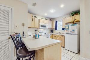 a kitchen with a counter and a white refrigerator at Barrier Dunes Hideaway in Oak Grove