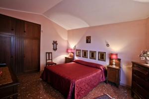 een slaapkamer met een rood bed en een rode deken bij Argentario Rooms - By The Sea in Porto Santo Stefano +33 foto's