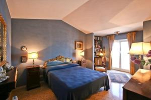 een blauwe slaapkamer met een bed en een raam bij Argentario Rooms - By The Sea in Porto Santo Stefano