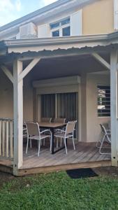 eine Terrasse mit Tisch und Stühlen auf einem Deck in der Unterkunft Refuge tropical entre mer et nature à Sainte-Rose Guadeloupe in Sainte-Rose + 9 Fotos