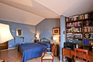 een slaapkamer met een bed en een boekenplank met boeken bij Argentario Rooms - By The Sea in Porto Santo Stefano