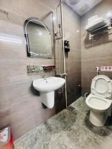 a bathroom with a toilet and a sink at Vinh Hotel in Thốt Nốt
