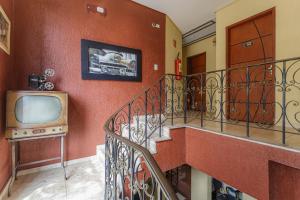 a living room with an old television and a staircase at Hotel do Museu no ipiranga com TV ventilador banheiro in São Paulo