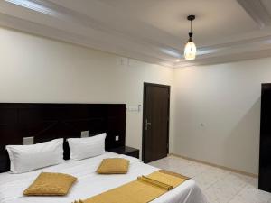 a bedroom with a large bed with two pillows on it at شقق الاوفاز للشقق المخدومة--إقتصادي in Qal'at Bishah